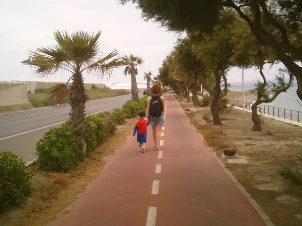 Madre temeraria caminando con su hijo de corta edad por el carril-bici de Almería.