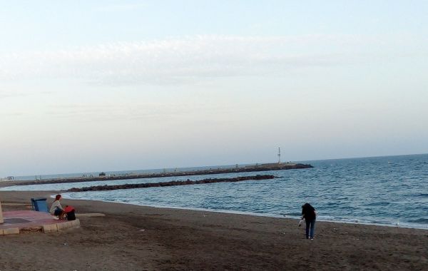 Una chica en Almería recoge basura dejada en la playa por usuarios bañistas