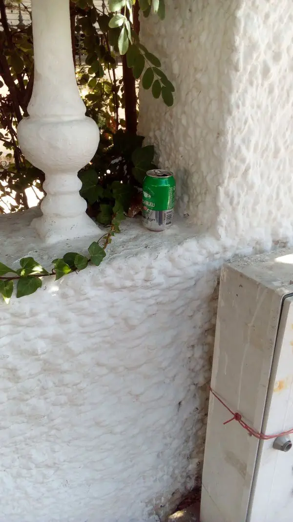 Lata de cerveza abandonada en pared de una vivienda de la Calle América en su tramo desde la Plaza España a Avda. Cabo de Gata.