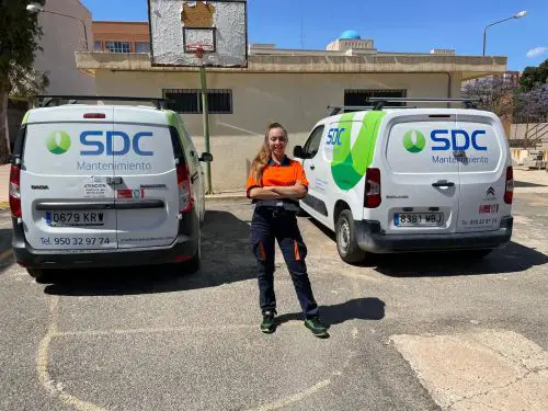 Alba María, junto a dos de los vehículos de la empresa “SDC” de Roquetas