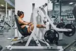 a woman sitting on a bench in a gym