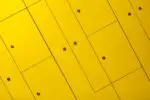 a close up of a yellow wall with rivets