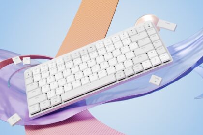a computer keyboard sitting on top of a purple ribbon
